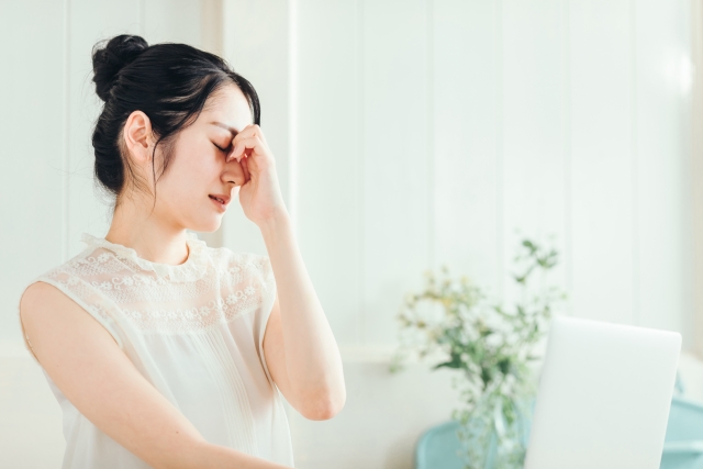 眉間を抑える女性